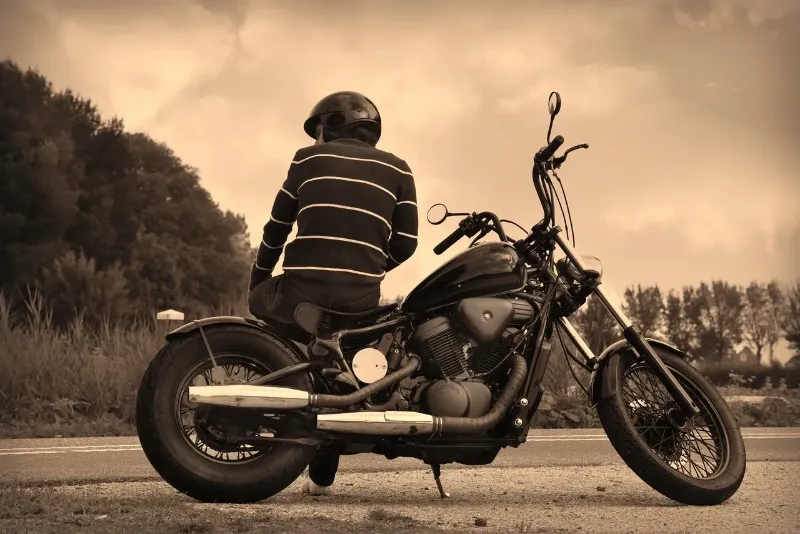 a man sitting sideways on his motorcycle