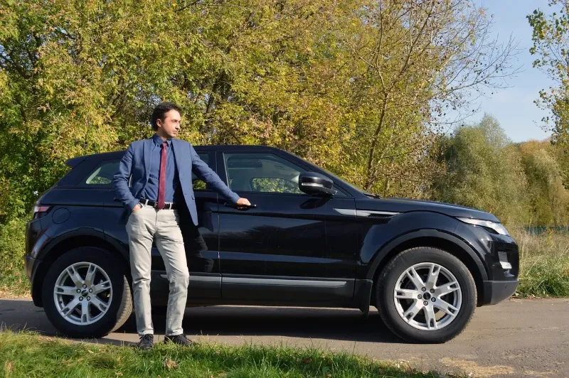 man next to his SUV posing for a picture