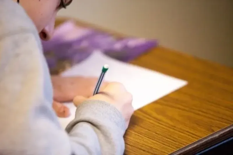 person writing on a piece of paper