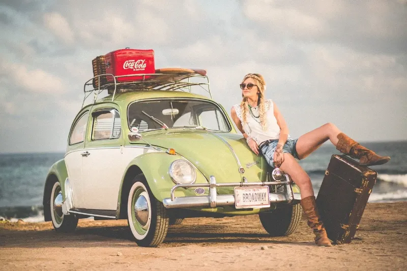 woman sitting on the front of her Volkswagon beetle 