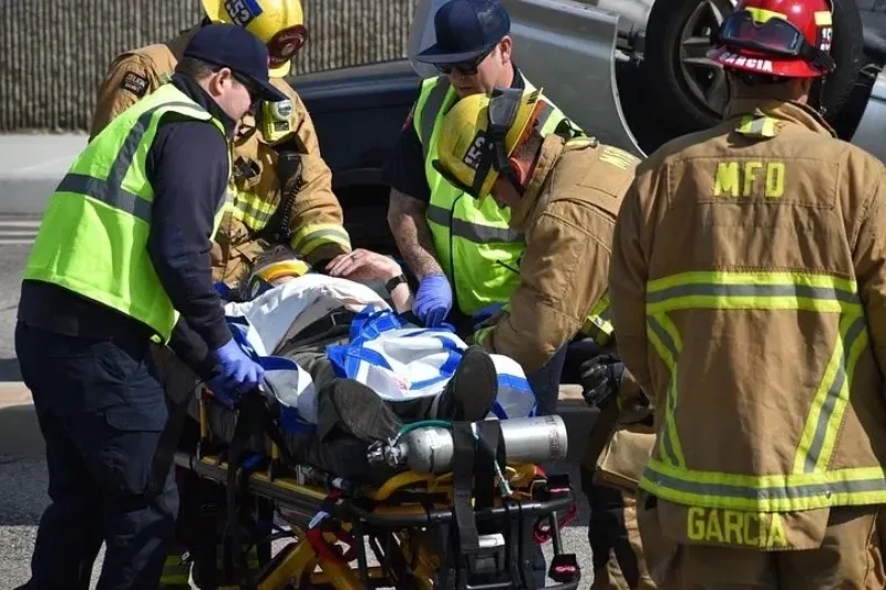 EMT and firemen treating a car accident victim on a stretcher