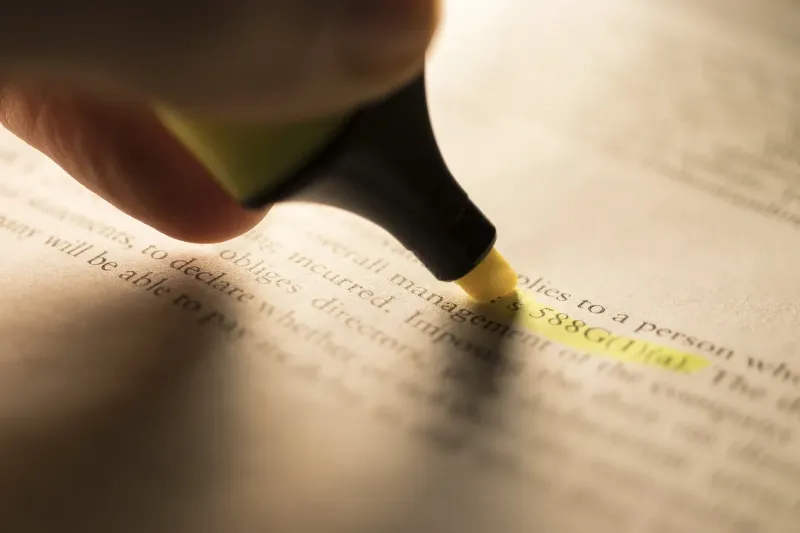 a person highlighting a line on a contract