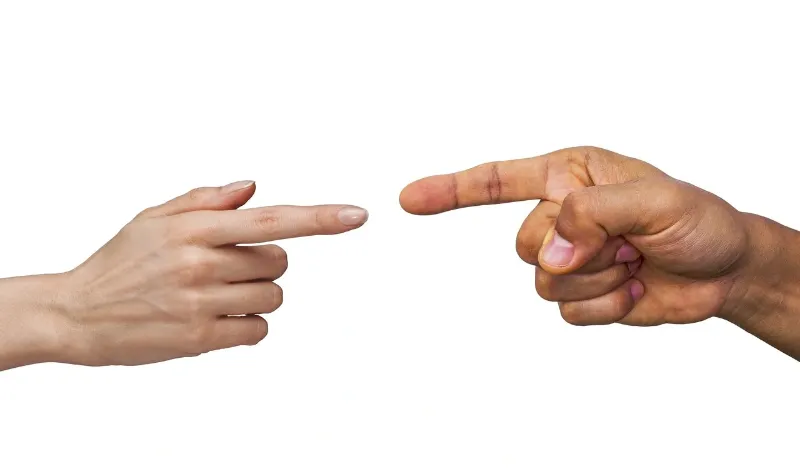 2 people pointing at each other