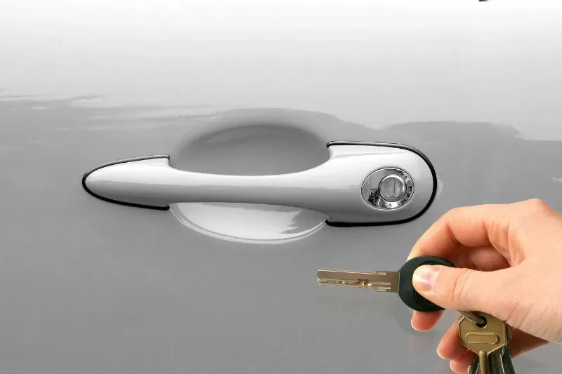 person unlocking a door to a car rental with a key