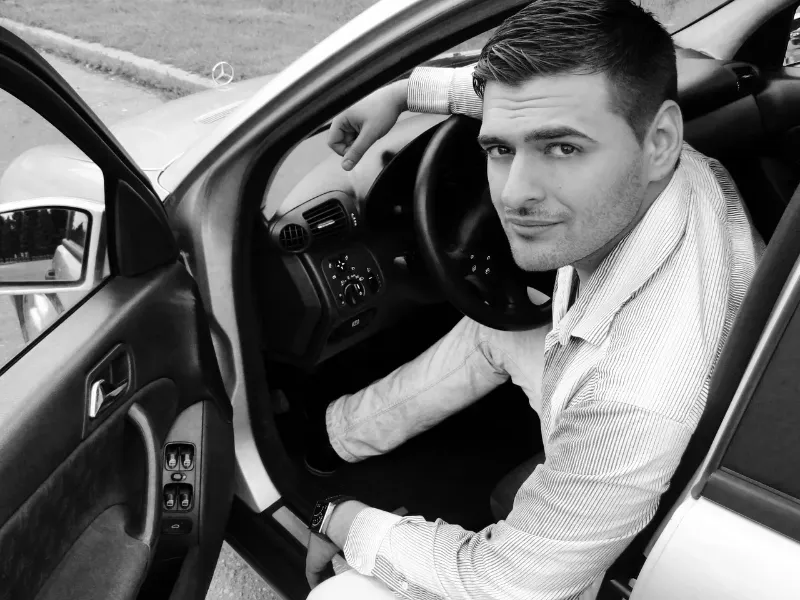 man inside his car with the driver's side door open